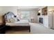 Bright bedroom featuring large window, tiled fireplace, and neutral colors; a comfortable retreat within the home at 10572 Jaguar Gln, Lone Tree, CO 80124