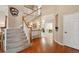 Elegant entryway with hardwood floors, a staircase with white railings, and abundant natural light creating a warm and inviting space at 10572 Jaguar Gln, Lone Tree, CO 80124