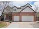 Charming two-story home with a brick facade and a spacious two-car garage, set against a bright blue sky with scattered clouds at 10572 Jaguar Gln, Lone Tree, CO 80124