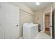 Convenient laundry room with modern washer and dryer, shelving, and ample space at 10572 Jaguar Gln, Lone Tree, CO 80124