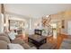 Comfortable living room showcasing hardwood floors, neutral decor, and an open layout leading to the dining area and staircase at 10572 Jaguar Gln, Lone Tree, CO 80124