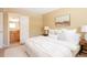 Bright bedroom with white comforter, neutral walls, and an en-suite bathroom at 654 S Xenon Ct, Lakewood, CO 80228