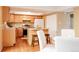 Cozy kitchen with light wood cabinets, island, and adjacent dining area at 654 S Xenon Ct, Lakewood, CO 80228