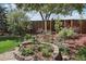 Landscaped backyard featuring a variety of flowering plants, mature trees, and a decorative birdbath at 1164 W 101St Pl, Northglenn, CO 80260