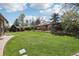 Expansive backyard featuring lush green lawn, mature trees, and a privacy fence at 1164 W 101St Pl, Northglenn, CO 80260