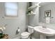 Cozy powder room features a pedestal sink, decorative shelves, and an elegant flower arrangement at 2184 Willow Ct, Denver, CO 80238