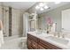 Modern bathroom with a double sink vanity, white marble countertop and bathtub shower at 2184 Willow Ct, Denver, CO 80238