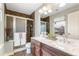 Elegant bathroom with double sinks, marble countertop, and glass-enclosed shower at 2184 Willow Ct, Denver, CO 80238