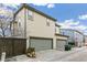 Side view of a tan two-story townhouse with a two-car garage and a gray driveway at 2184 Willow Ct, Denver, CO 80238