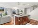 Open concept kitchen flowing into living and dining areas, features kitchen island and stainless steel dishwasher at 2184 Willow Ct, Denver, CO 80238