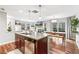 Open concept kitchen flowing into living and dining areas, features kitchen island and stainless steel dishwasher at 2184 Willow Ct, Denver, CO 80238