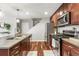 Well-lit kitchen with stainless steel appliances, cherry wood cabinets, granite countertops, and hardwood floors at 2184 Willow Ct, Denver, CO 80238