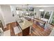 Open concept kitchen flows into living and dining areas with hardwood floors, island seating, and abundant natural light at 2184 Willow Ct, Denver, CO 80238