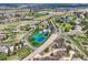 Expansive aerial view of a property featuring tennis courts and a pool, surrounded by lush green spaces and a residential area at 6411 Sand Rose Ct, Castle Rock, CO 80108