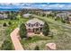 Inviting aerial view of a landscaped property featuring a flag, lush trees and a winding driveway in a serene neighborhood at 6411 Sand Rose Ct, Castle Rock, CO 80108