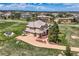 Breathtaking aerial view of a spacious estate featuring a manicured lawn, mature trees, and a circular driveway at 6411 Sand Rose Ct, Castle Rock, CO 80108
