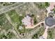 Overhead view of a beautiful residence with a winding driveway, stone patio, and a well-manicured lawn in a serene setting at 6411 Sand Rose Ct, Castle Rock, CO 80108