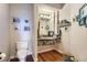 Stylish powder room with unique granite vanity, framed photos, and hardwood floors at 6411 Sand Rose Ct, Castle Rock, CO 80108