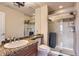 Well-lit bathroom featuring a glass shower, granite countertop, and large mirror at 6411 Sand Rose Ct, Castle Rock, CO 80108