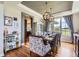 Formal dining area with elegant chandelier, hardwood floors, and views of the backyard at 6411 Sand Rose Ct, Castle Rock, CO 80108