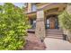Inviting front entrance with decorative wood door, stone accents, and manicured landscaping at 6411 Sand Rose Ct, Castle Rock, CO 80108