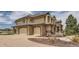 Elegant home featuring an attached three-car garage with stone accents and a wide driveway at 6411 Sand Rose Ct, Castle Rock, CO 80108