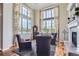Bright living room featuring large windows, hardwood floors, fireplace, and stylish seating at 6411 Sand Rose Ct, Castle Rock, CO 80108