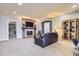Comfortable living room with a stone fireplace, tv, hardwood floors and an elegant display cabinet at 6411 Sand Rose Ct, Castle Rock, CO 80108