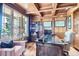 Wood-paneled office featuring custom built-ins, a large desk, and plenty of natural light at 6411 Sand Rose Ct, Castle Rock, CO 80108