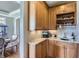 Cozy wet bar featuring light wood cabinets, granite countertops, and a charming wine rack for entertaining at 6411 Sand Rose Ct, Castle Rock, CO 80108