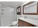 Compact bathroom featuring shower with glass door, vanity with stylish countertop and fixtures, and mirror at 6368 S Harlan Way, Littleton, CO 80123