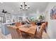 Open-concept dining area with chandelier lighting, and views to the kitchen and living room at 6368 S Harlan Way, Littleton, CO 80123