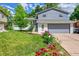 Charming two-story home featuring a well-manicured lawn and colorful flower beds at 6368 S Harlan Way, Littleton, CO 80123