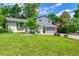 Landscaped front yard with mature trees and a well-maintained lawn around the house at 6368 S Harlan Way, Littleton, CO 80123