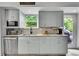 Bright kitchen featuring stainless steel appliances, gray cabinets, and a granite countertop, next to an open door at 6368 S Harlan Way, Littleton, CO 80123