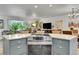 Kitchen island with gray cabinets, granite countertops, and modern appliances. Open to the living areas at 6368 S Harlan Way, Littleton, CO 80123