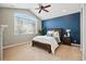 Primary bedroom with a vaulted ceiling, large window, carpet flooring, and blue accent wall at 10103 Bluffmont Ln, Lone Tree, CO 80124