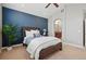 Bedroom with blue accent wall, carpet flooring, ceiling fan, and ensuite bathroom at 10103 Bluffmont Ln, Lone Tree, CO 80124