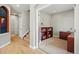 Inviting hallway with wood floors that leads to a carpeted office space with built-in bookshelves at 10103 Bluffmont Ln, Lone Tree, CO 80124