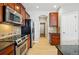 Well-lit kitchen with stainless steel appliances, cherry cabinets, granite counters, and wood flooring at 10103 Bluffmont Ln, Lone Tree, CO 80124