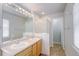 Bathroom featuring double sinks, shower stall and window bringing in light at 3355 Willowrun Dr, Castle Rock, CO 80109