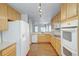 Open kitchen with oak cabinets, white appliances, and a view of the dining area at 3355 Willowrun Dr, Castle Rock, CO 80109