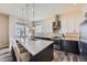 Modern kitchen features a granite island with seating, stainless steel appliances, and sleek cabinets, perfect for entertaining at 7010 W Alaska Dr, Lakewood, CO 80226