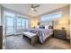 Serene primary bedroom featuring soft carpet, natural light, a ceiling fan, and a private door to a balcony at 7010 W Alaska Dr, Lakewood, CO 80226