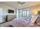 Modern bedroom with balcony access, large window, ceiling fan, and a flat screen TV at 7010 W Alaska Dr, Lakewood, CO 80226