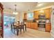 Eat-in kitchen with wood cabinetry, stainless steel appliances, and sliding glass door to the deck at 18619 E Vassar Dr, Aurora, CO 80013