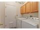 Practical laundry room with a side-by-side washer and dryer and overhead storage at 18619 E Vassar Dr, Aurora, CO 80013