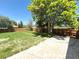 Spacious backyard featuring a large, well-maintained lawn, a concrete patio, and a privacy fence at 2895 Poplar St, Denver, CO 80207
