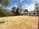 Large backyard with wood fence, patchy grass and a sidewalk leading to the back door of the house at 2895 Poplar St, Denver, CO 80207