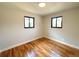 This bedroom features wood floors, neutral walls, and two windows that let in natural light at 2895 Poplar St, Denver, CO 80207